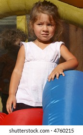 Cute Toddler Girl Posing In Front Of A Bounce House