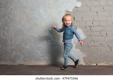 Cute Toddler Girl Posing Joyfully To Camera. Dancing, Jumping, Running, Laughing. Vintage Background. Happy Childhood, Beautiful Baby. Denim Clothes.