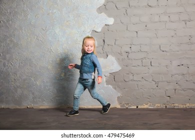 Cute Toddler Girl Posing Joyfully To Camera. Dancing, Jumping, Running, Laughing. Vintage Background. Happy Childhood, Beautiful Baby. Denim Clothes.