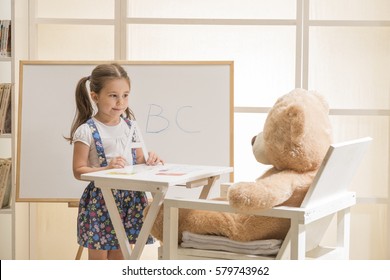 Cute Toddler Playing Teacher Role Game. Little Girl Teaching Her Teddy Bear Friend Alphabet. Learning Letters. Learn Study Education School Knowledge Concept