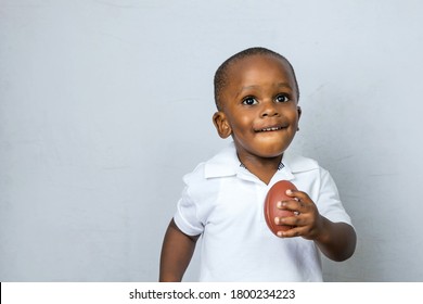 Cute Toddler Preschool Age Little Boy Playing With A Football Toy