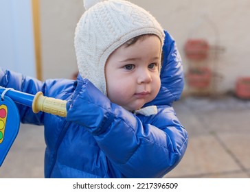 Cute Toddler Is Riding His Toy Scooter And Push Car In The Back Yard