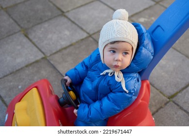 Cute Toddler Is Riding His Toy Scooter And Push Car In The Back Yard