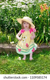 Cute Toddler In  A Yellow Sun Dress Wearing A Big Floppy Straw Hat