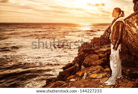 Cute tourist girl enjoying warm sunset light on the cliff, traveling to South Africa, adventure lifestyle, travel and tourism concept