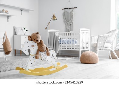 Cute Toy Bear Sitting On Rocking Horse In Child's Room