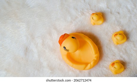 Cute Toy Yellow Rubber Duck On White Fur Texture Background Family Concept