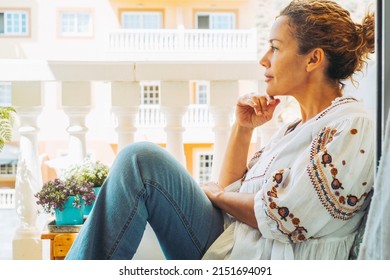 Cute Trendy Woman Sitting Outside Home In The Terrace Having Relax Time Looking In Front. Side Portrait Of Young Adult Female People Thinking And Enjoying Life. Serene People Concept