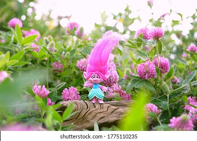 cute troll on summer floral meadow, natural background. Queen Poppy - modern popular toy hasbro trolls. concept of children's games, fun, toys, friendship, holiday, happiness