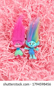 cute trolls on pink paper straws abstract background. Harper Pinsel and Queen Poppy - modern toy hasbro trolls. concept of children's games, fun, toys, friendship. flat lay