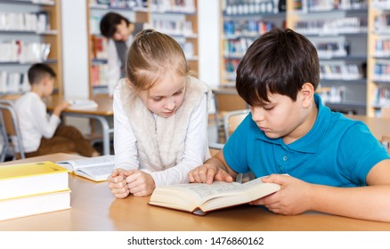 Cute Tween Girl And Intelligent Boy Studying Together In School Library, Reading Books