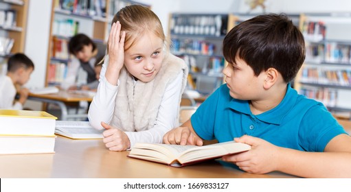 Cute Tween Girl And Intelligent Boy Studying Together In School Library, Reading Books