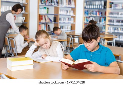 Cute Tween Girl And Intelligent Boy Studying Together In School Library, Reading Books