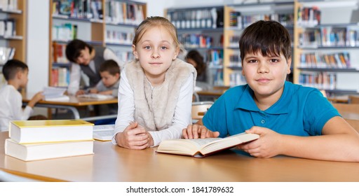 Cute Tween Girl And Intelligent Boy Studying Together In School Library, Reading Books