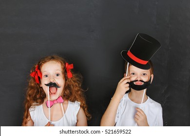  Cute twins kids hold carnival mustache   beard  father day concept 
