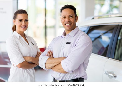 Cute Vehicle Sales Staff With Arms Crossed In Car Showroom