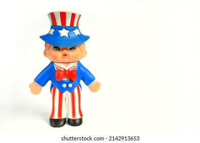 Cute Vintage 1970s Uncle Sam Rubber Boy Doll Toy. Wearing A Red, White, And Blue Stars And Stripes Outfit. Isolated On White Background With Space For Copy Text.