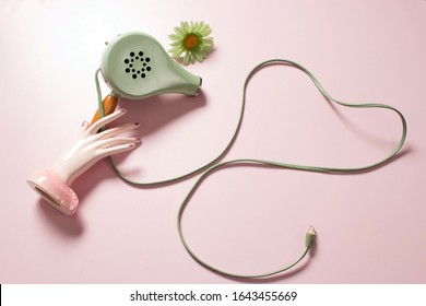 Cute Vintage Blow Dryer On Rose Colour Background. Styling Tool From The 1950's Or 1960's. Heat Blower For Drying And Styling. Minimal Concept With Muted Colours. Self Care Grooming Tools. Copy Space.