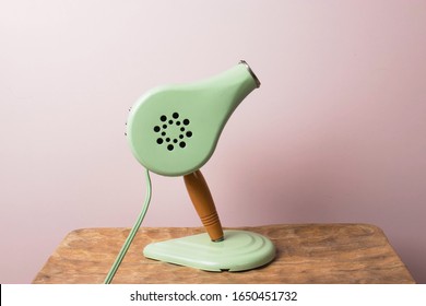 Cute Vintage Blow Dryer On Rose Colour Background. Styling Tool From The 1950's Or 1960's. Heat Blower For Drying And Styling. Minimal Concept With Muted Colours. Self Care Grooming Tools. Copy Space.