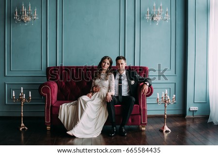 cute wedding couple in the interior of a classic studio decorated. hey kiss and hug each other