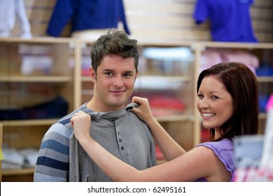 Cute Woman Choosing Clothes For Her Boyfriend In A Shop