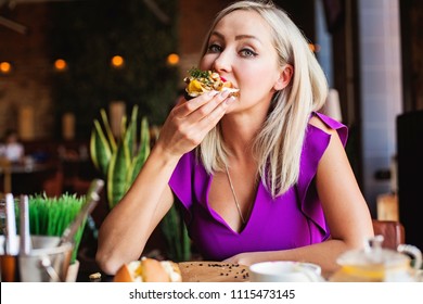 Cute Woman eating tasty danish smorrebrod in restaurant 