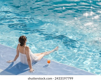 Cute woman with a glass of drink sits near the swimming pool of a cruise ship. Sunny, clear morning. View from above. Closeup, outdoors. Vacation and travel concept - Powered by Shutterstock