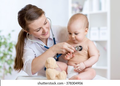 Cute woman pediatrician examining of baby kid with stethoscope