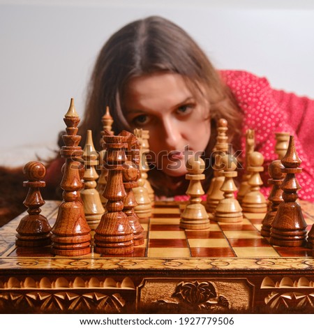 Cute woman playing chess with herself, close-up portrait