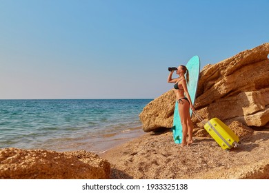 Cute Woman With Suitcase On Seashore. Girl Looking Away Through Binoculars. New Horizons, New Life And Future Concept