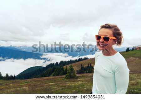 Cute woman wearing neon sunglasses poses at Hurriance Ridge in Olympic National Park in Washington State