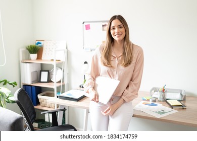 Cute Woman Working As An Administrative Assistant Holding A Laptop Computer In An Office And Looking Ready To Work