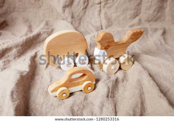 Cute wooden handmade toys for kids on\
natural linen background. Handcrafted\
toys