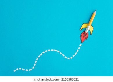 Cute yellow color pencil rocket paper cut drawing on blue background copy space. Concept of creative idea, innovation, start up business and education. Launch to success goal.