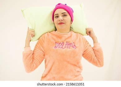 Cute Young Asian White Woman Wearing Pink Pajamas, With A Pillow And A Night Cap Ready To Sleep, Smiling For A Good Day, On White Background