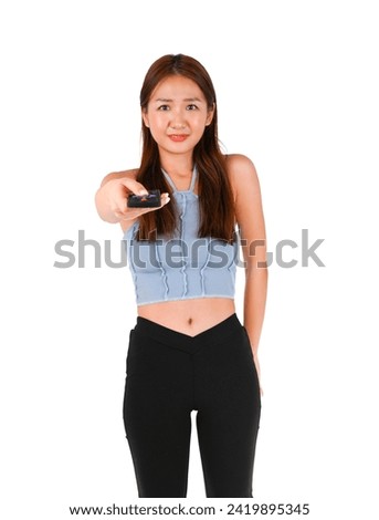 Cute young asian woman holding a remote control against a white background