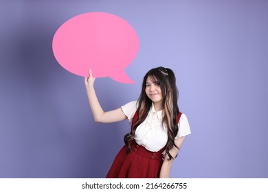 The Cute Young Asian Woman With Preppy Dressed Standing On The Purple Background.