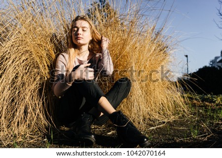 cute young blonde girl enjoying the sun outdoors, eyes closed