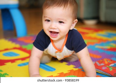 A cute young boy baby playing inside home with colorful toys