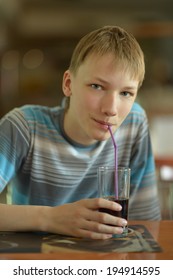 Cute Young Boy Drink Coke In Cafe