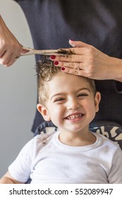 Cute young boy getting a haircut at home
