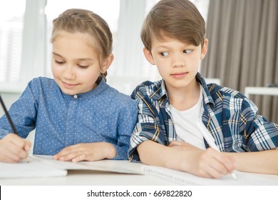 Cute Young Boy Studying In Class With His Friend Copying From Her Notebook During An Exam Cheating Education Intelligence Lazy Learner Pupil Student Childhood Kids Elementary School Concept