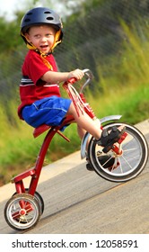 Cute Young Boy Wearing Safety Helmet Riding Tricycle