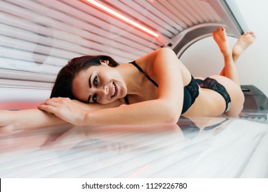 A Cute Young Brunette Woman In A Swimsuit Lies In A Sunroom, Wants A Beautiful Even Tan