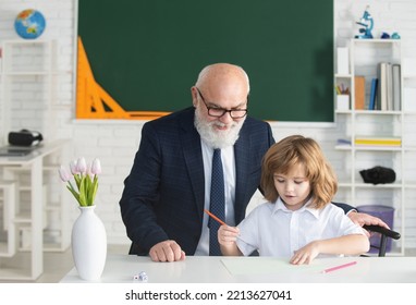 Cute Young Child In Class At School. Senior Teacher And At Home Working. Happy Family Old Grandfather And Grandson Learning. Elderly Teacher Trainer Teen Pupil Boy.