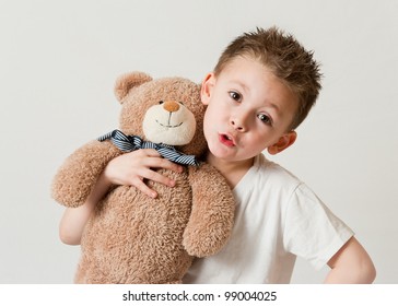 Cute Young  Child In White T Shirts Holding A Teddy Bear On A White Background