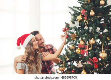 Cute, young couple decorating a Christmas tree - Powered by Shutterstock
