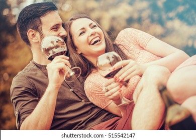 Cute Young Couple Drinking Red Wine On A Picnic In Park.