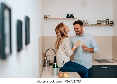 Cute young couple drinking wine in kitchen. - Powered by Shutterstock