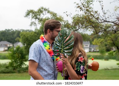 Cute Young Couple Enjoying Tropical Drinks And Conversation In The Backyard